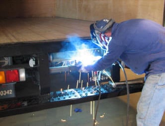 Worker welding flatbed